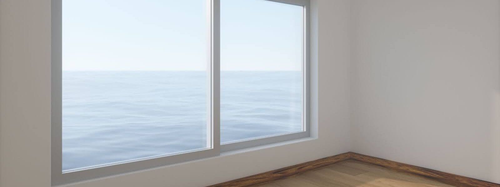 A window in an empty white-walled and hardwood floored room