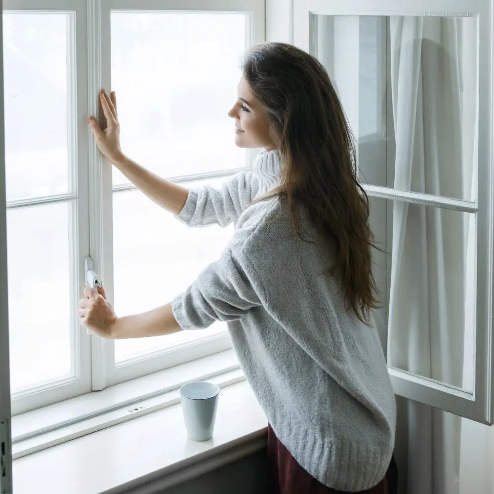 Woman Opening Window For Fresh Air