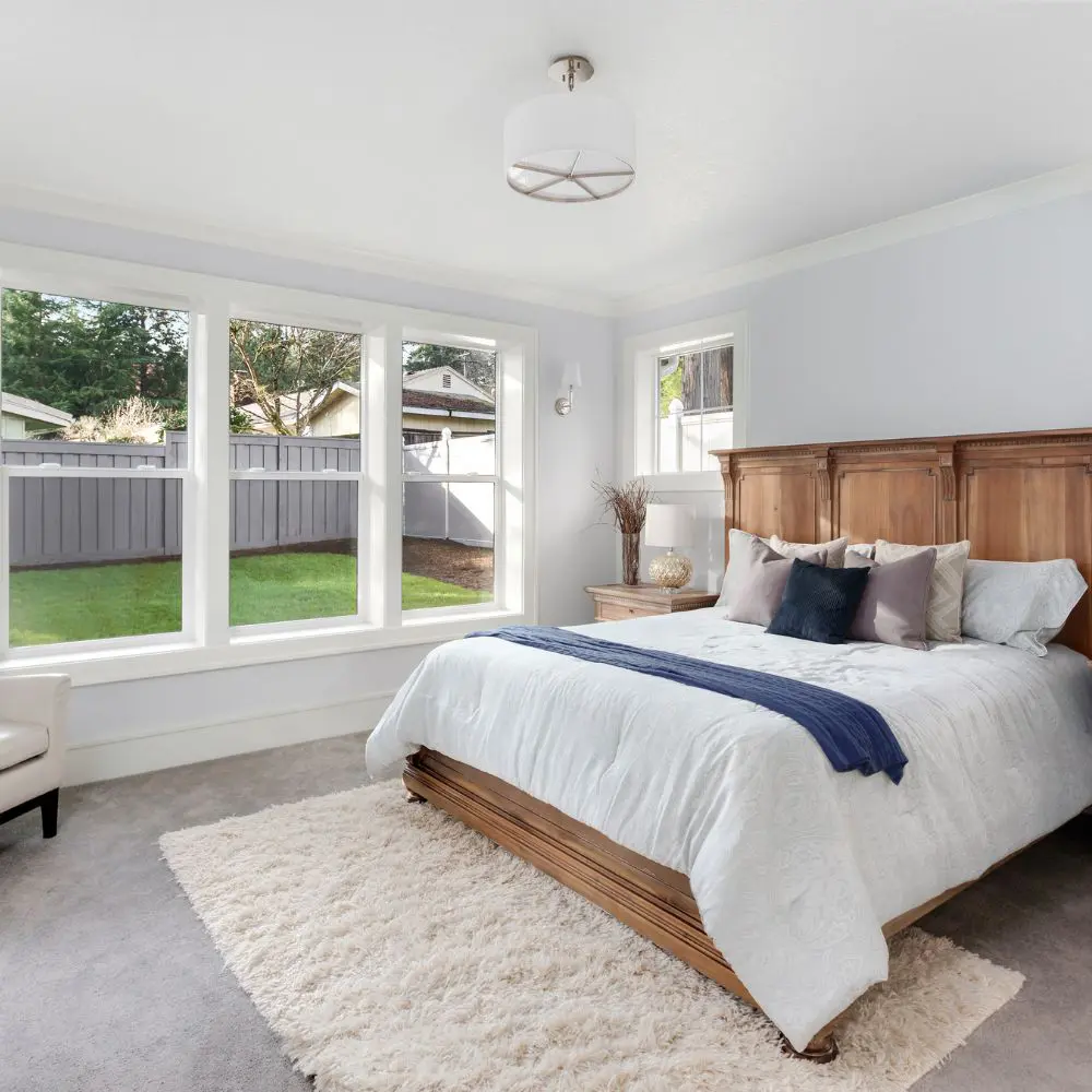 Bright Bedroom With Large Windows And Backyard View